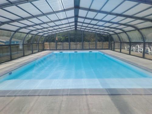 AzurLandes Azur mobil home 38 m2 7km de vieux boucau的一个带玻璃屋顶的室内游泳池