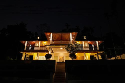 a house at night with lights on it at The Calm County Homestay in Mānantoddy