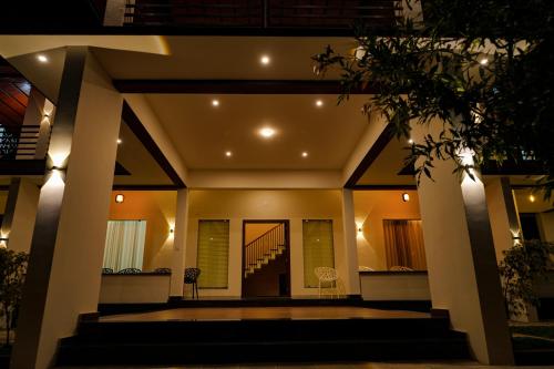 a view of a house at night with lights at The Calm County Homestay in Mānantoddy