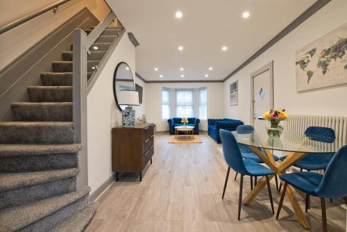 a living room with a staircase and a table and chairs at Newly refurbished house in Romford