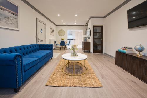 a living room with a blue couch and a table at Newly refurbished house in Romford