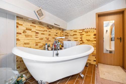 a white bath tub in a bathroom with wooden walls at Ostseeblick in Kröslin
