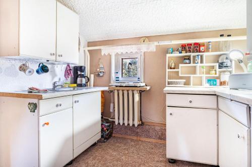 a kitchen with white cabinets and a sink at Ostseeblick in Kröslin