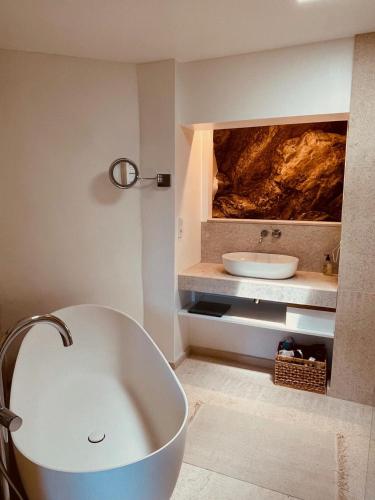 une salle de bain avec une baignoire et un lavabo dans l'établissement Authentic renovated villa, pool, magnificent view, à La Garde-Freinet