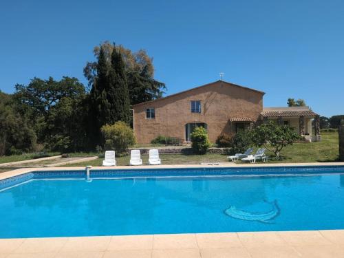 une grande piscine devant une maison dans l'établissement Gitedeprovence le castelet, à La Motte