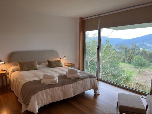 a bedroom with a large bed and a large window at Exclusiva casa con jardín en Gondomar in Gondomar