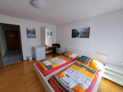 two twin beds in a room with white walls at good bed Aarwangen in Aarwangen