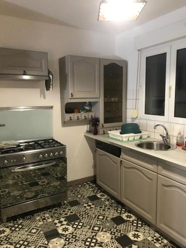 une cuisine avec une cuisinière et un évier dans l'établissement Duplex, à La Celle-sous-Gouzon