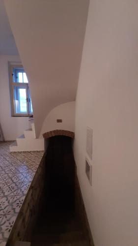 a stairway with a white wall and a window at Chaloupka u Lovoše in Velemín