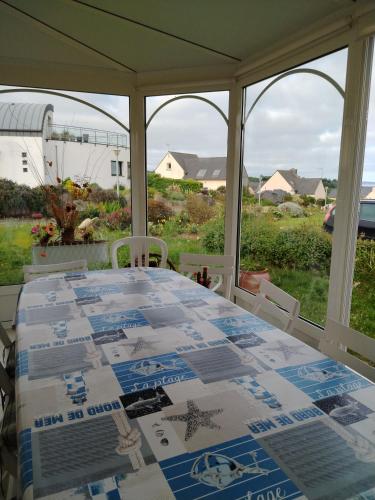 un porche grillagé avec une table avec vue sur un champ dans l'établissement Mon Rêve, à Locquémeau