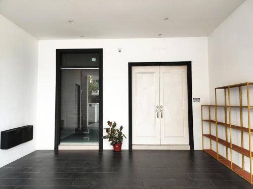 a hallway with two doors and a potted plant at Cyberjaya Puchong JWJ Pool Villa in Cyberjaya