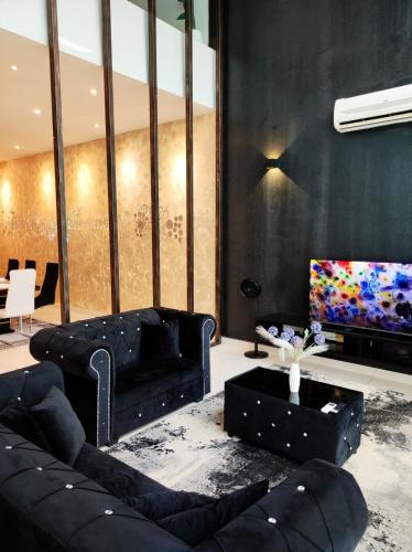 a living room with black furniture and a flat screen tv at Cyberjaya Puchong JWJ Pool Villa in Cyberjaya