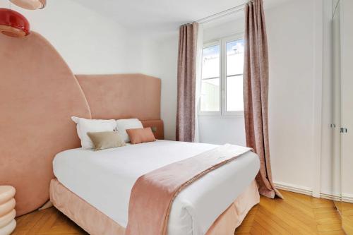 une chambre avec un lit blanc avec une grande fenêtre dans l'établissement Appartement Élégant & Spacieux - 3BR-6P - Républiq, à Paris