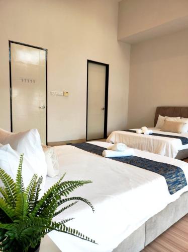a room with two beds and a plant at Cyberjaya Puchong JWJ Pool Villa in Cyberjaya