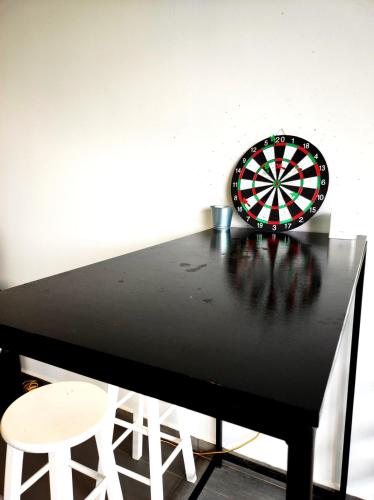 a dart board on a black table with two stools at Cyberjaya Puchong JWJ Pool Villa in Cyberjaya