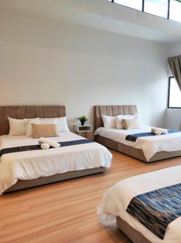 two beds in a room with wooden floors at Cyberjaya Puchong JWJ Pool Villa in Cyberjaya
