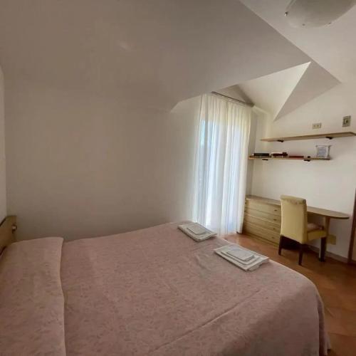 a bedroom with a bed and a desk and a window at Locanda Da Teresa in Bardineto