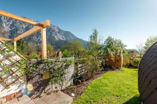a garden with a fence and a mountain in the background at StoderGarden Apartment - by myNests in Gröbming