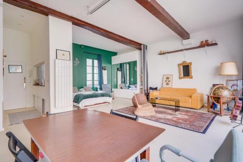 un salon avec une table et un canapé dans l'établissement Exceptionnel Loft Bordeaux Centre, à Bordeaux