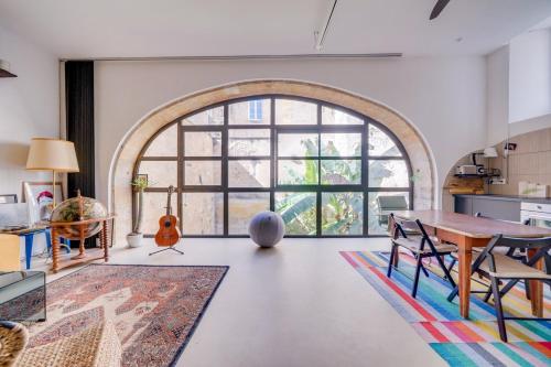 un salon avec une table et une grande fenêtre dans l'établissement Exceptionnel Loft Bordeaux Centre, à Bordeaux