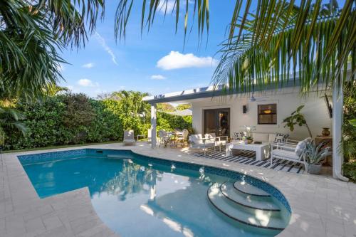a swimming pool in front of a house at New! Luxurious Villa with Pool in West Palm Beach in Ibis Isle