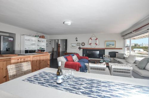 a kitchen and living room with a bottle of wine on a table at Voetjieshang in Yzerfontein