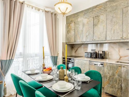 une salle à manger avec une table et des chaises vertes dans l'établissement Merveil - Luxury Suite - Louvre - Marcel II, à Paris
