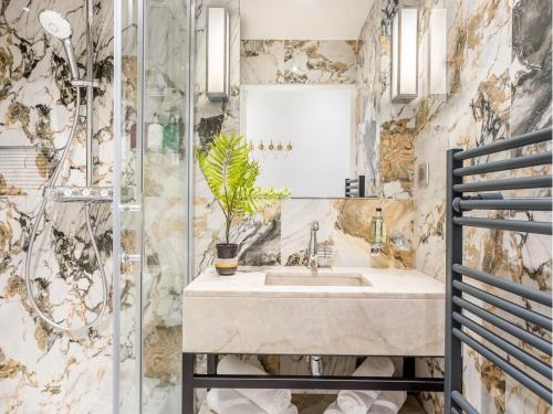 une salle de bain avec un lavabo et une douche dans l'établissement Merveil - Luxury Suite - Louvre - Marcel II, à Paris