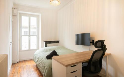 a bedroom with a desk and a bed and a tv at Le Gare Nord T3 de Haut Standing Cosy et Relaxant in Nantes