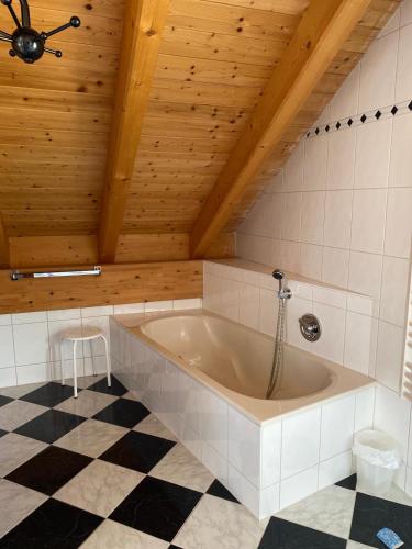 a bath tub in a room with a wooden ceiling at Techendorf 101 in Weissensee
