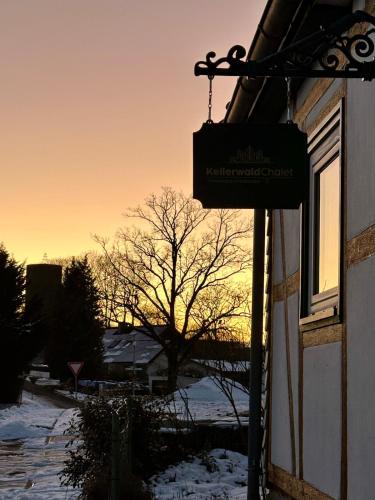 a sign on the side of a building in the snow at Ferienhaus KellerwaldChalet in Jesberg mit großem Garten zur Alleinnutzung in Jesberg