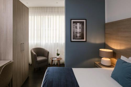 a hotel room with a bed and a chair at The Howard Hotel in Sliema