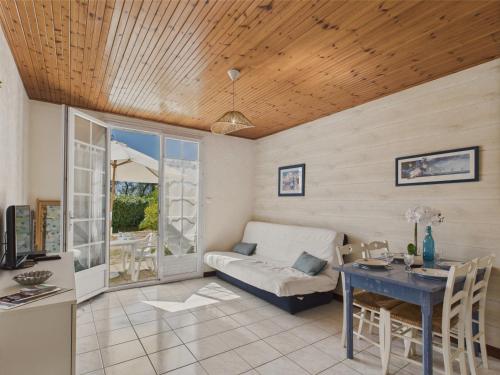 un salon avec une table et un canapé dans l'établissement Appartement pour 4 - Terrasse - 100m du Port, à Saint-Hilaire-de-Talmont