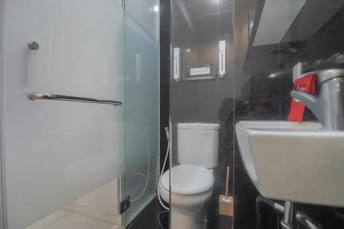 a small bathroom with a toilet and a sink at RedDoorz Plus near Parahyangan University in Bandung