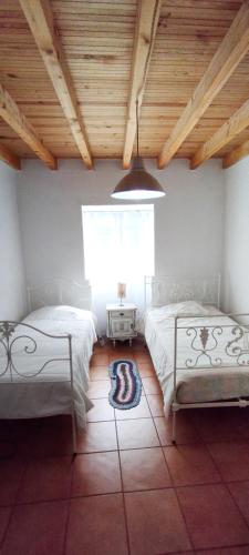a bedroom with two beds and a window at Casa da Bica in Alvalade