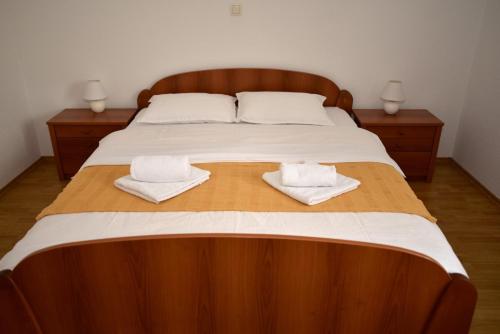 a large wooden bed with two towels on it at Sutjeska in Modriča