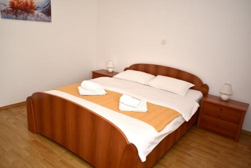 a large wooden bed with two white towels on it at Sutjeska in Modriča