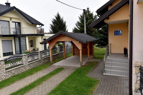 a wooden pavilion in a yard next to a house at Sutjeska in Modriča