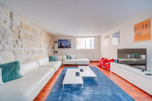 un salon avec un canapé blanc et une télévision dans l'établissement Spacious, quiet flat in the heart of Bordeaux, à Bordeaux