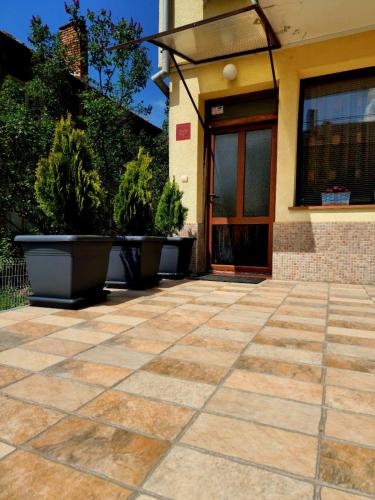 a patio with potted plants in front of a building at Rebeka Guest House in Tryavna