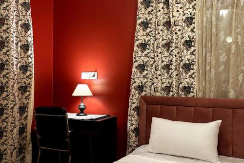 a bedroom with a bed and a desk with a chair at Blue Bells Highway Lodge, Srinagar in Srinagar