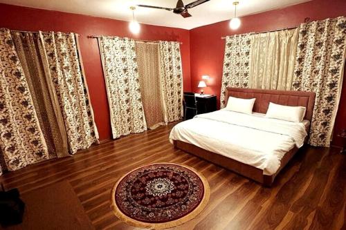a bedroom with a bed with red walls at Blue Bells Highway Lodge, Srinagar in Srinagar