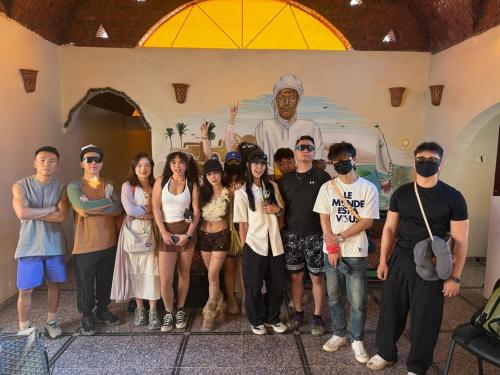 a group of people posing for a picture in front of a statue at DoroKa Nubian House in Aswan