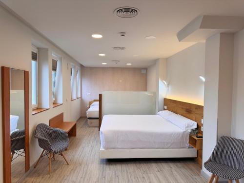 a hospital room with a bed and two chairs at Hotel Marqués de Aguilar in Aguilar de Campóo