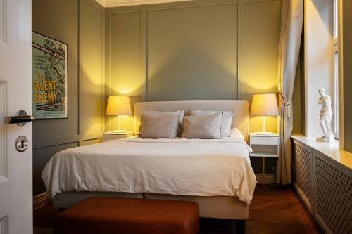 a bedroom with a large bed with two lamps at Luxurious Inner-City Flat in Malmö