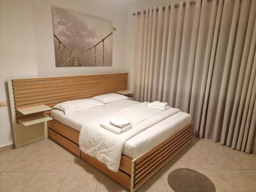 ein Schlafzimmer mit einem großen Bett mit weißer Bettwäsche in der Unterkunft Beachfront Apartment in Sarandë