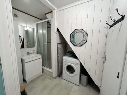 une salle de bain avec une machine à laver et un lavabo dans l'établissement Villa climatisée dans résidence LES TAMARIS, 3 chambres, véranda, Wifi, à 400m de la plage de Portiragnes LRTAMG15, à Portiragnes