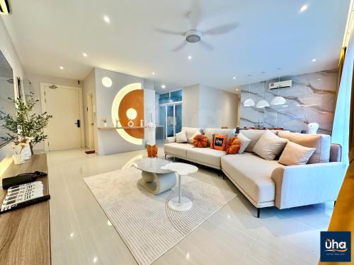 a living room with a white couch and a table at Medini Signature Suites by RR JBcity in Nusajaya