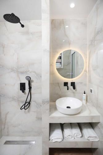 a bathroom with a sink and a mirror at Danae Comfort Living in Pefkochori