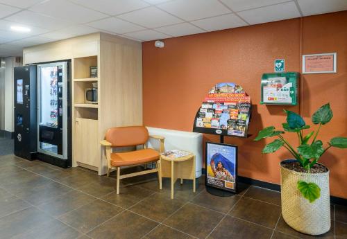 a waiting room with a chair and a vending machine at B&B HOTEL Toulouse Cité de l'Espace Hurel in Toulouse